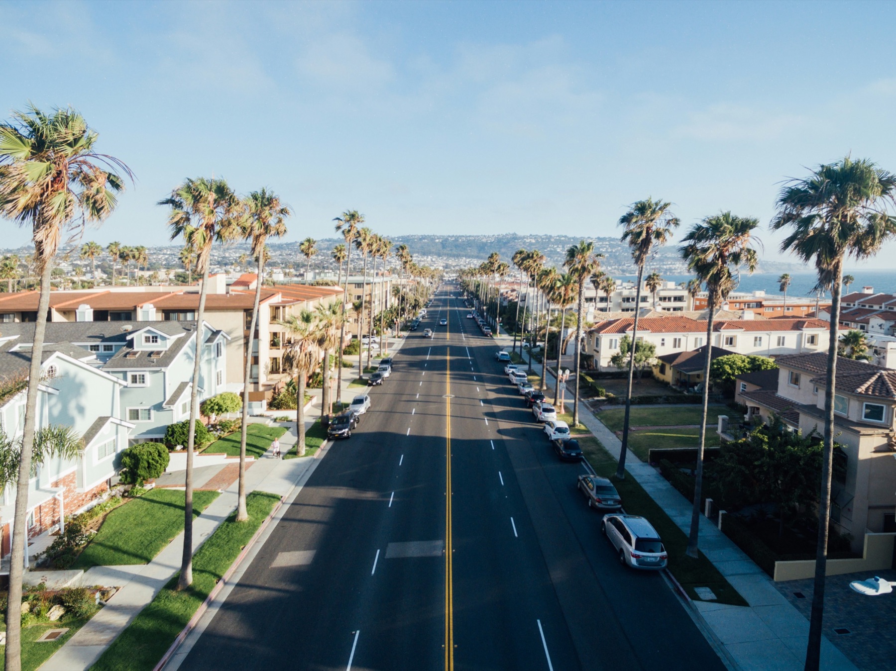 A palm-lined Santa Barbara street leading toward the coast and foothills